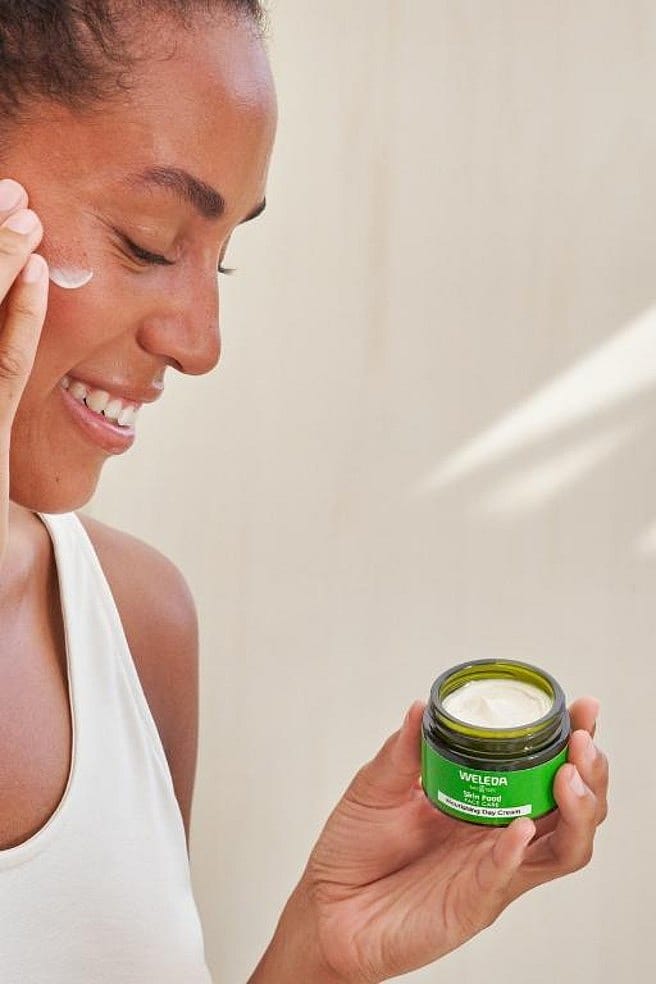 Vrouw doet Skin Food Voedende dagcrème op