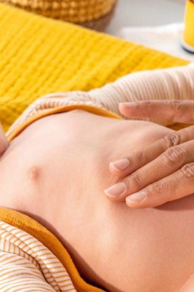 Mère caressant le ventre d'un bébé