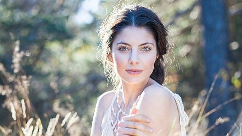 Einer jungen Frau scheint Sonne ins Gesicht