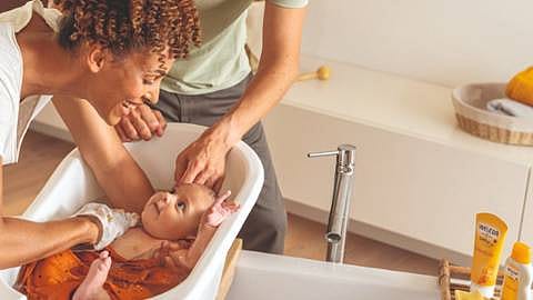 Une mère baigne son bébé avec Weleda