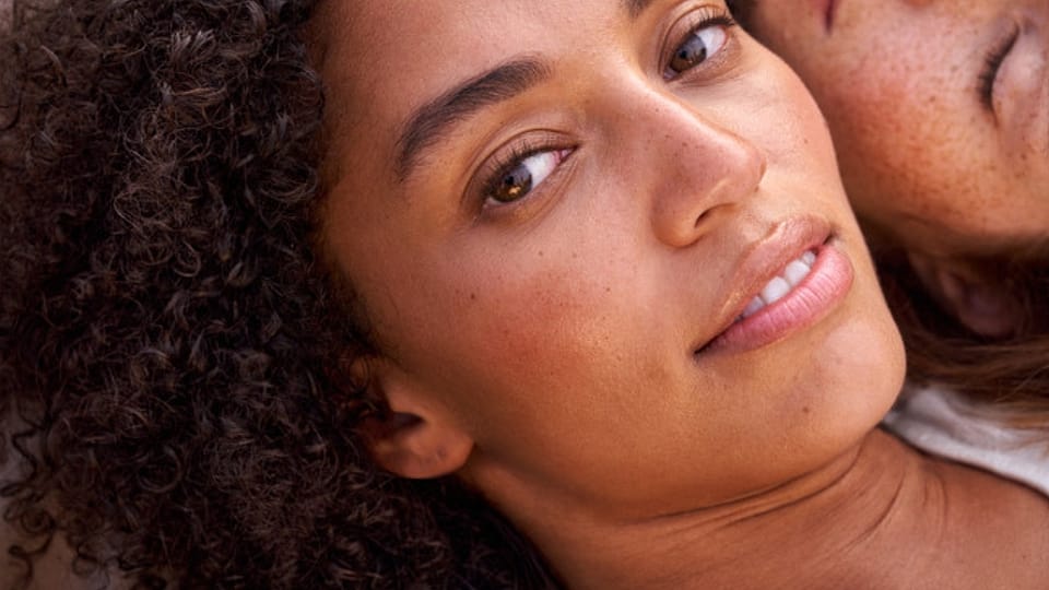 Vrouw die crème smeert op haar wang