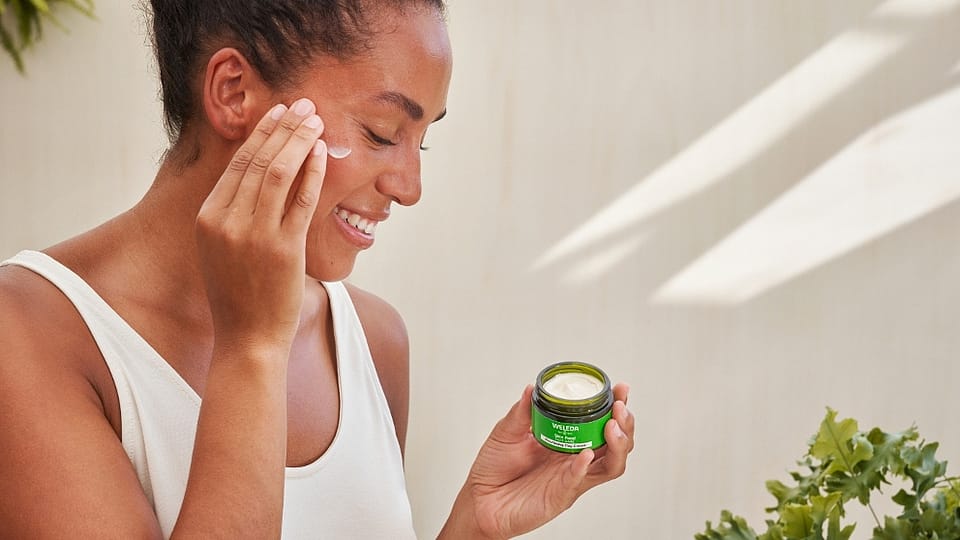 Vrouw doet Skin Food Voedende dagcrème op