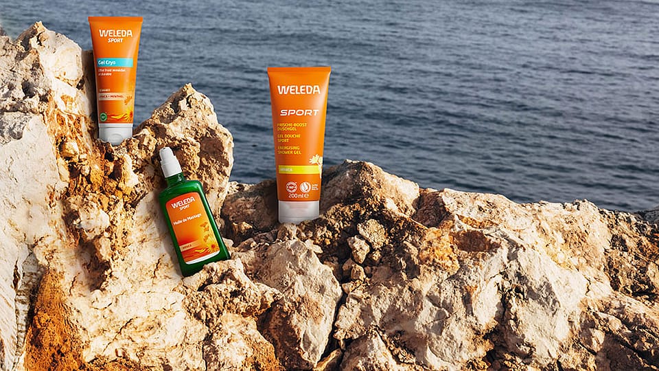 Weleda Arnika Produkte auf einem Felsen am Meer