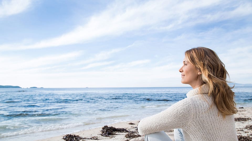 Frau sieht aufs Meer hinaus