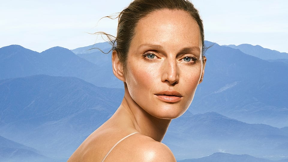 Portrait einer Frau mit blauen Bergen im Hintergrund