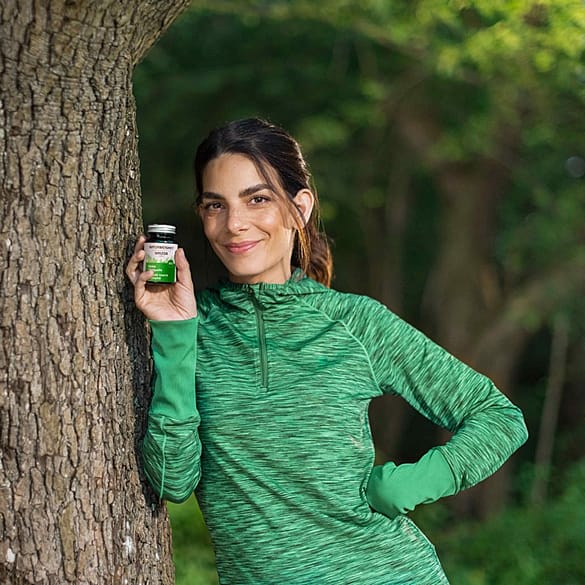 Sportliche Frau am Baum