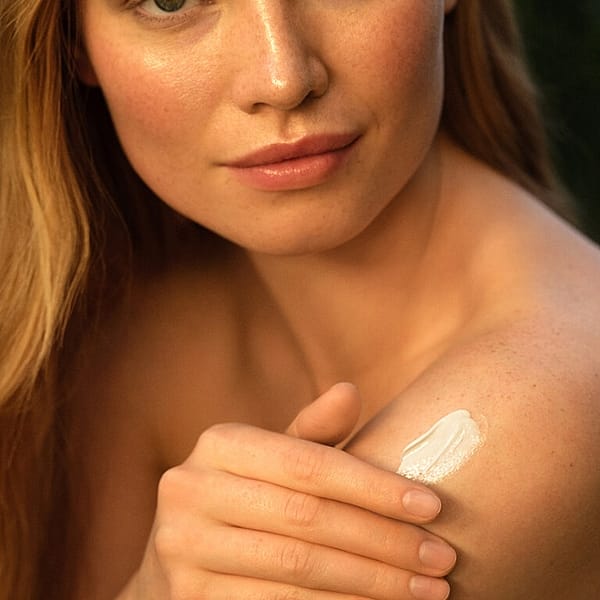 Young woman applying Bodylotion