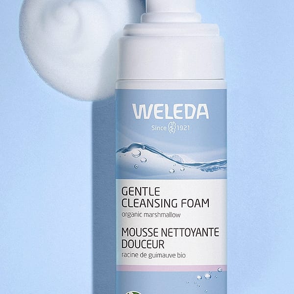 Open Gentle Cleansing Foam bottle on a light blue background with foam texture next to it.