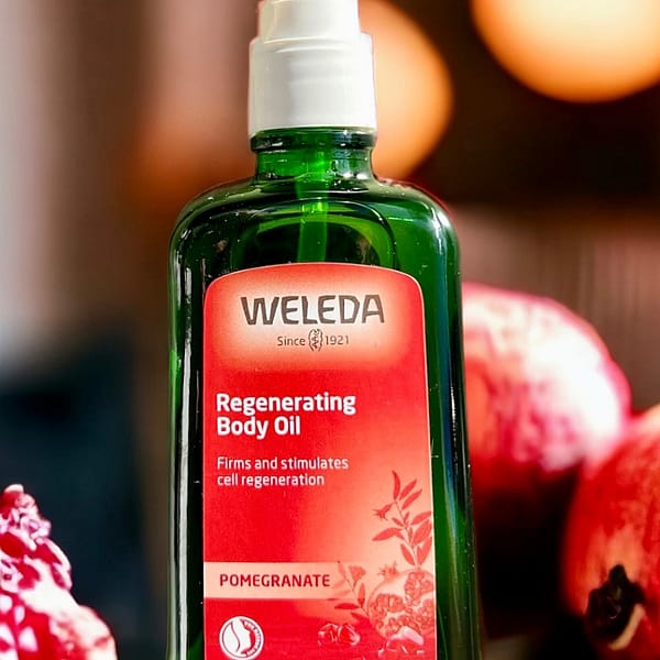 Regenerating Body Oil Pomegranate surrounded by pomegranates.