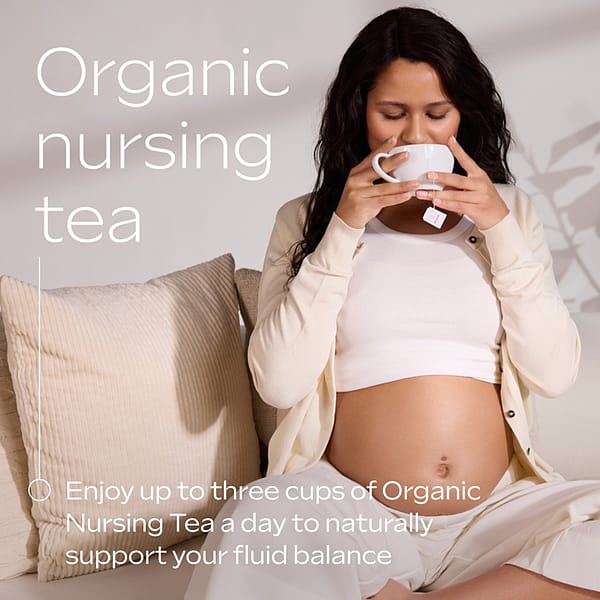 Organic Nursing Tea. A pregnant woman sits comfortably on a sofa, dressed in a white crop top and cream cardigan, holding a cup of organic tea. She is gently sipping the tea, with a tea bag label visible. The text overlay reads: "Organic nursing tea. Enjoy up to three cups of Organic Nursing Tea a day to naturally support your fluid balance