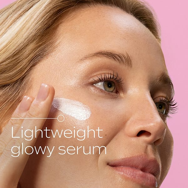 Close-up of a woman applying lightweight glowy serum to her cheek, demonstrating the smooth texture and radiant finish of Glow-Perfecting Serum Booster Drops for luminous, healthy skin.