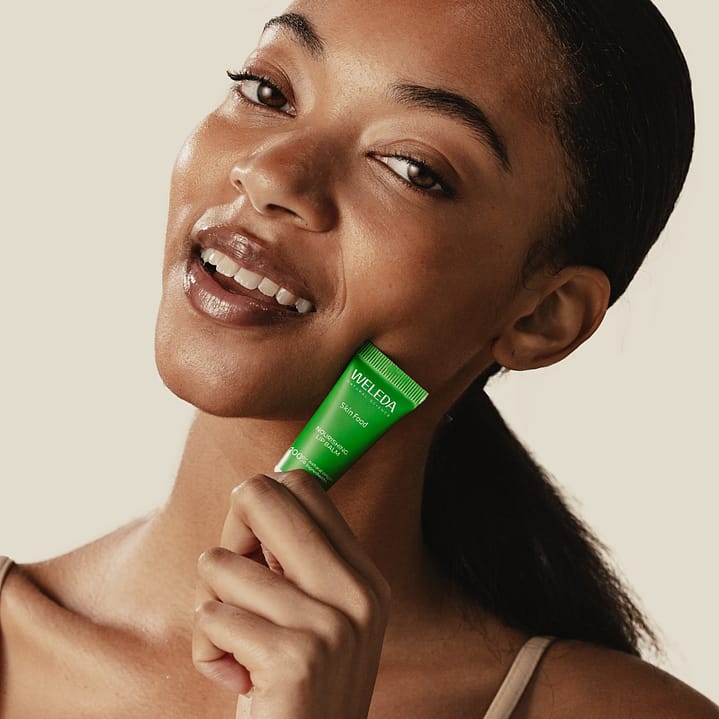 Model holding Skin Food Lip Balm