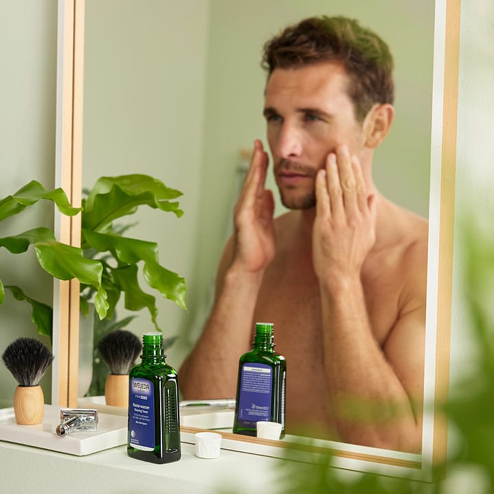 Man applying after shave lotion